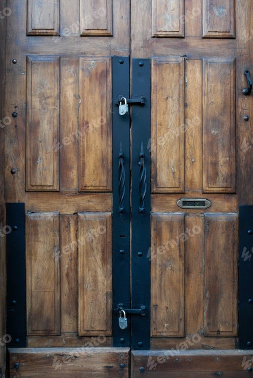 Preview: Vertical shot of a wooden door with iron locks