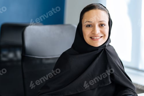 Preview: Beautiful arabian woman with abaya dress working in the office