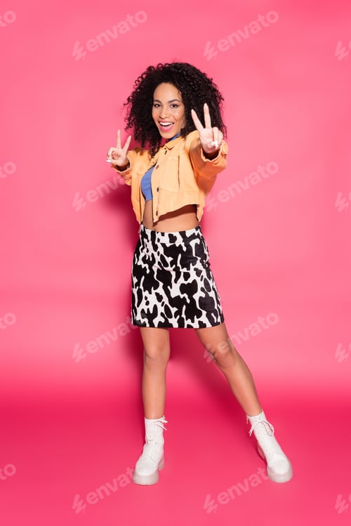 Preview: full length of positive african american woman in crop top, jacket and skirt with animal print