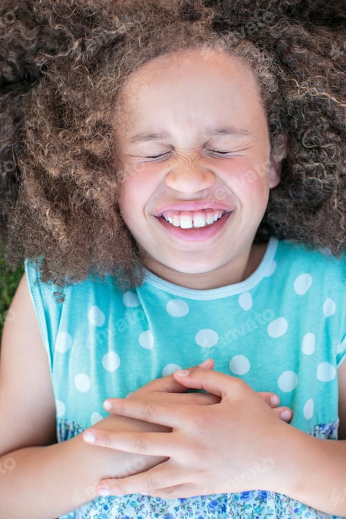 Preview: Portrait of girl lying on grass, laughing, overhead view