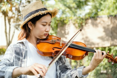Preview: Close-up portrait of Young Asia woman music violinist play the violin, relax in the garden