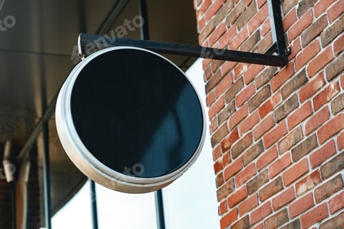 Preview: Empty black round signboard on the brick wall