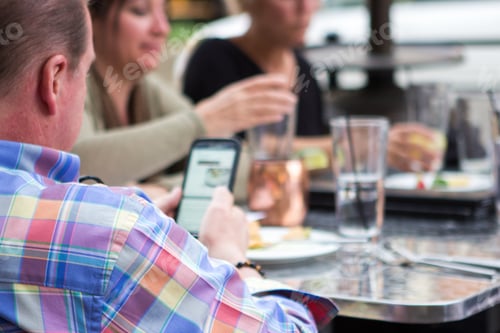 People Dining Together At Restaurant with Smart Phone