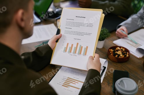 Preview: Marketing Strategy Report with Graphs Placed on Desk in Office