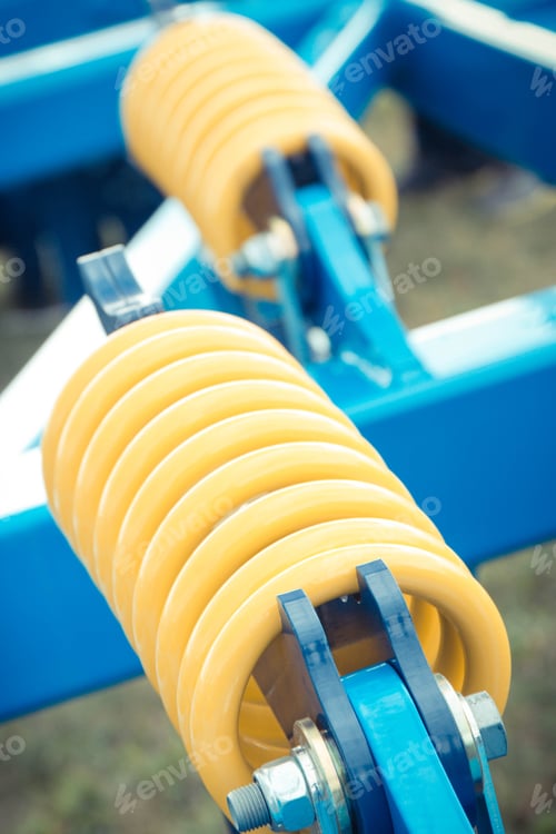 Preview: Hard yellow spring made of steel. Part of big industrial or agricultural machine