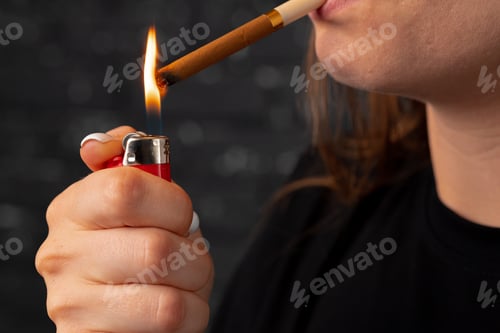 Preview: Unrecognizable woman lights cigarette with fire lighter