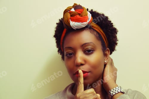 Preview: Woman Poses with Finger to Lips in Studio