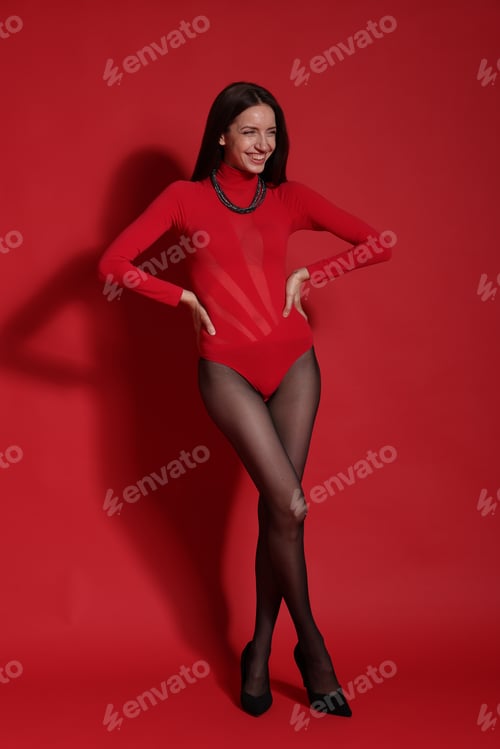 Preview: Full-length portrait of beautiful woman in stylish outfit on red background
