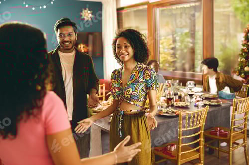 Preview: Happy friends enjoying in conversation during festive dinner at home party