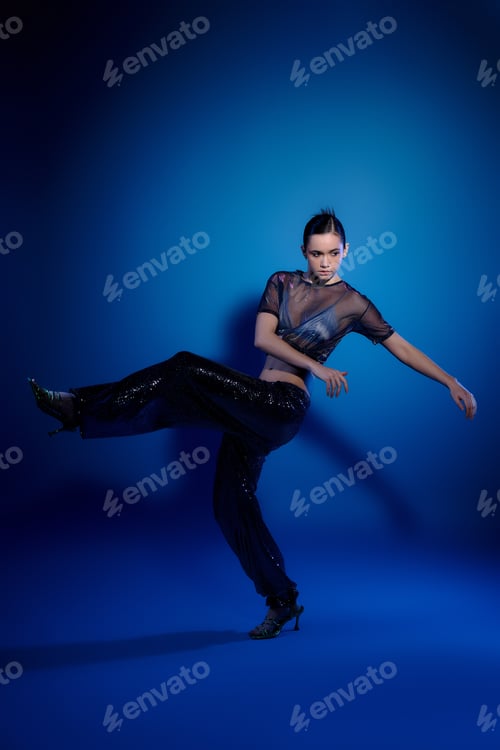Preview: Stylish young woman showcases modern fashion in a vibrant studio scene