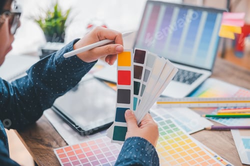 Preview: Graphic designer architects who work with laptops and color comparison tables for design work.