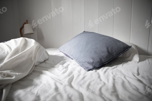 Preview: Unmade bed and bedside lamp