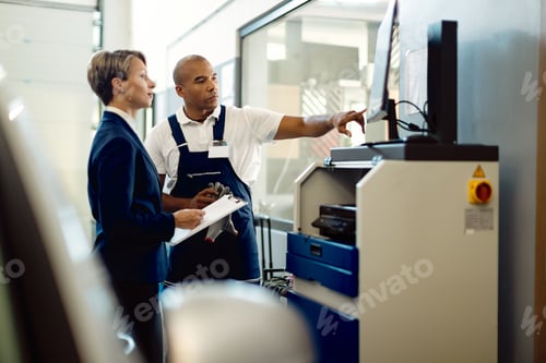 Preview: African American auto mechanic and businesswoman using computer in repair shop.