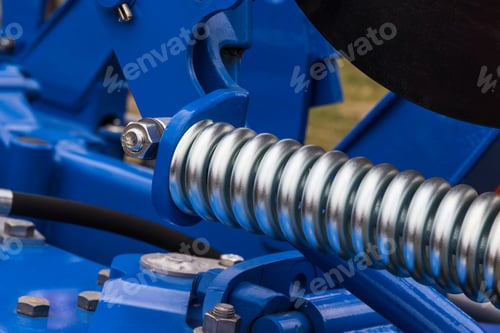 Preview: Silver hard spring made of steel. Part of big blue industrial or agricultural machine