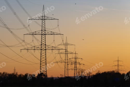 Preview: Line of transmission towers with a colorful sky during the sunset