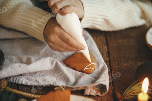 Preview: Decorating gingerbread cookie tree with frosting on rustic table. Making christmas cookies