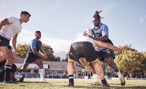 Preview: Caucasian rugby player attempting to tackle an opponent during a rugby match outside on the field.