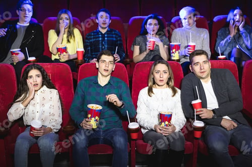 Preview: Young scared couple at the cinema watching.