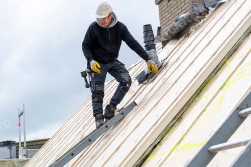 Preview: Portrait of tradesman on a roof wearing safety gear and hard hat