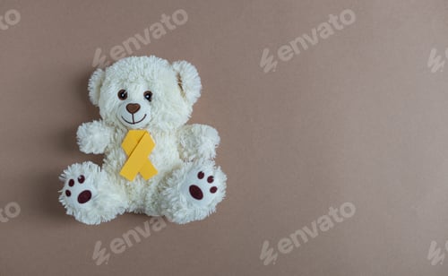 Preview: Toy bear with a yellow ribbon on a nude background.