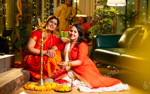 Preview: Working on rangoli design, Indian woman and mother celebrate Diwali in festive indoor setup