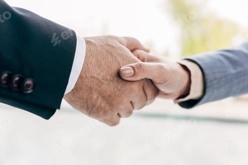 Preview: cropped view of businesspeople shaking hands on blurred background