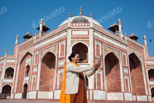 Preview: Indian woman taking selfie with smartphone in front of Humayun's Tomb
