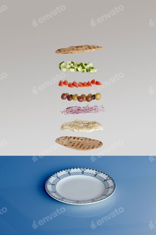Preview: A deconstructed sandwich floating above a classic bluerimmed plate against a dualtone background.