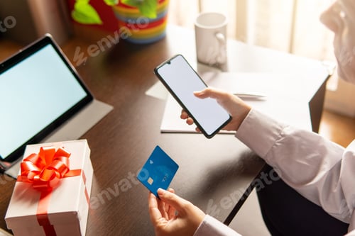 Preview: Woman using smartphone with credit card, ordering online shopping. Working from home concept