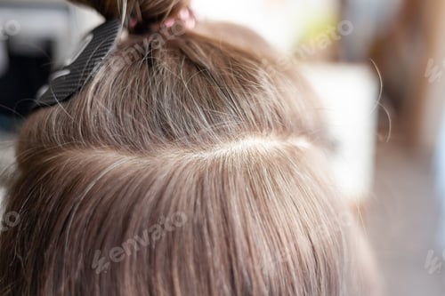Preview: Hair ribbons for extensions on a woman's head at home.