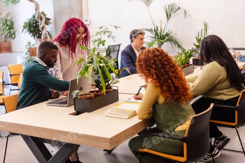 Preview: Diverse startup team collaborating on laptop during office meeting