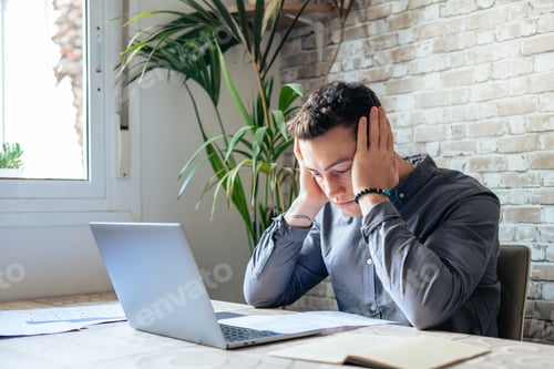 Preview: Confused frustrated young man reading letter, debt notification, bad financial report