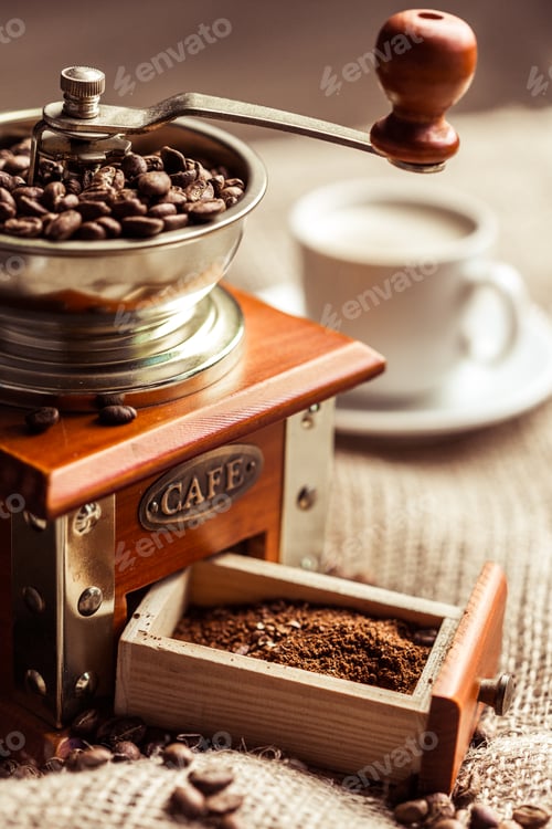 Preview: Coffee grinder with fresh beans and a cup of coffee on a rustic table