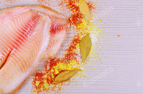 Preview: Above view raw fresh tilapia fillets over on cutting board