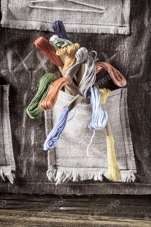 Preview: Closeup of colored threads in rustic sewing workshop