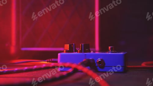 Preview: loop pedal for electric guitar. Close up of effect machine on concert scene. Macro view. Neon light.