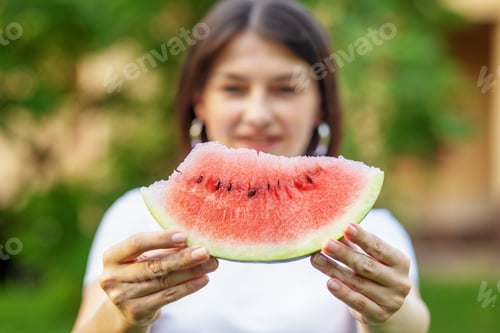 Preview: Beautiful brunette woman eating watermelon on picnic