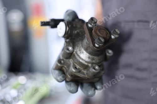 Preview: Auto part. Professional mechanic with power steering pump indoors, closeup. Space for text