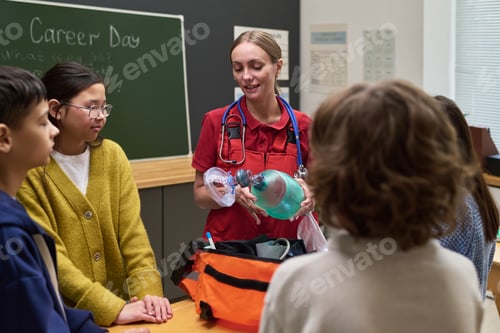 Preview: Caucasian Young Adult Female Paramedic Demonstrating Medical Equipment to Teenagers