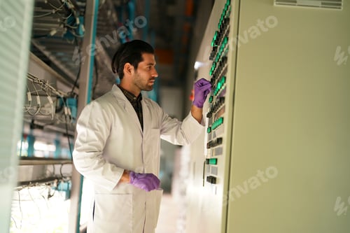 Preview: Technician working on control panel in industrial facility during daytime