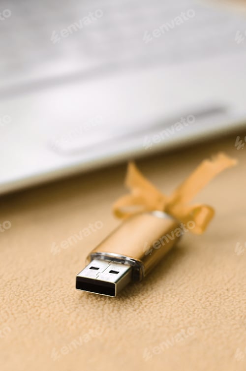 Preview: Orange usb flash memory card with a bow lies on a blanket of soft and furry li
