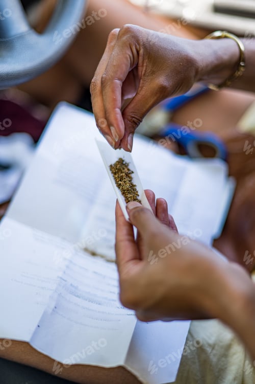 Preview: Woman rolling cannabis joint