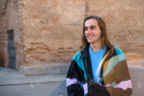 Preview: Man smiling while sitting outdoors at the street.