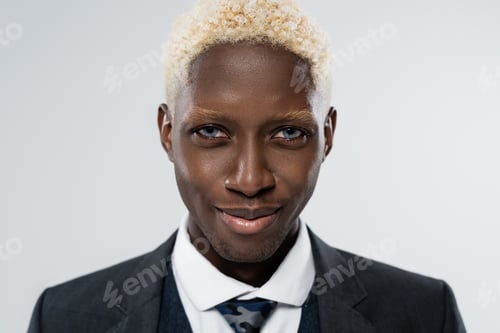 Preview: portrait of blonde and young african american man with blue eyes smiling isolated on grey