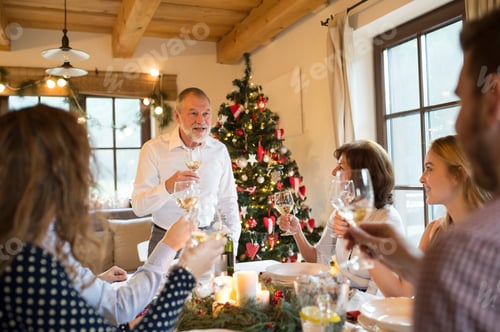 Preview: Senior man holding a speech with family at Christmas dinner