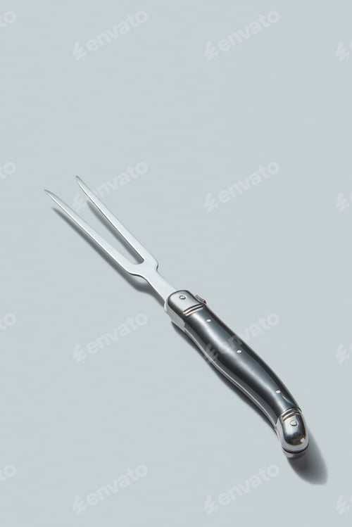 Preview: Steel kitchen fork for meat isolated on a white background with shadows, place for text