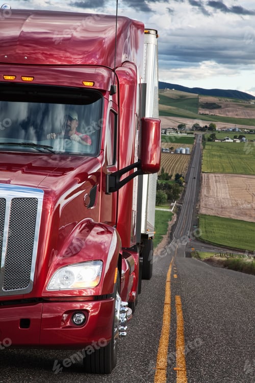 Preview: Close up view of the cab and driver of a commercial truck on the highway.