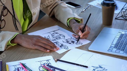 Preview: Cropped view of african american designer drawing sketches near devices and paper cup in studio