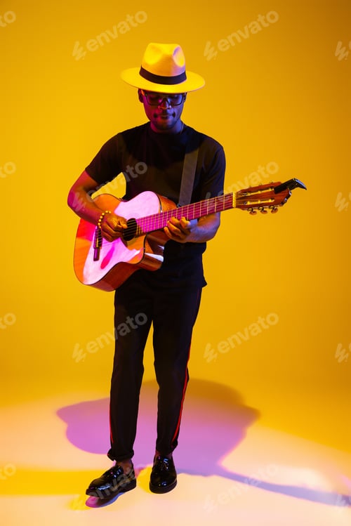 Preview: Young african-american musician singing, playing guitar in neon light