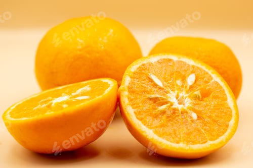 Preview: Oranges on pink background. One orange is cut in half, the other is whole.